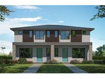 A modern two-story townhome featuring large windows and a beautifully landscaped front yard at 1005 W Cypress St # 1, Tampa, FL 33606