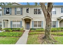 Charming townhome with blue shutters and lush landscaping in a well-maintained community at 15855 Fishhawk View Dr, Lithia, FL 33547