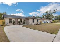 Charming single-story home with a well-maintained lawn and a long concrete driveway at 1818 Kim Acres Ln, Dover, FL 33527