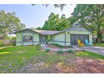 Charming single-story home with a well-maintained lawn, two-car garage, and exterior rocking chairs at 22115 Laver Ln, Land O Lakes, FL 34639