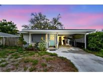 Charming home with a covered carport, front porch, and light blue door at 361 Colonial Ct, Dunedin, FL 34698