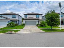 Charming two-story home with a well-manicured lawn and a two car garage at 9324 Rally Spring Loop, Wesley Chapel, FL 33545