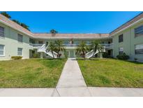 Charming condo building with lush landscaping, white railings, and a welcoming entrance at 1250 S Pinellas Ave # 214, Tarpon Springs, FL 34689