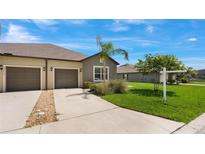 Charming home featuring a two-car garage, well-maintained lawn, and a welcoming driveway at 13423 Crest Lake Dr, Hudson, FL 34669