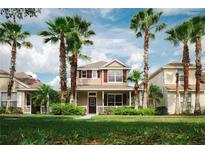 Charming two-story home with front porch and lush landscaping under a partly cloudy sky with palm trees at 20039 Heritage Point Dr, Tampa, FL 33647