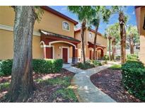 Inviting two-story townhome with landscaped walkway, mature trees, and covered entryways at 2220 Chianti Pl # 8-0828, Palm Harbor, FL 34683