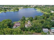 Stunning aerial view of lakefront property surrounded by lush greenery and mature trees at 2814 W Humphrey St, Tampa, FL 33614