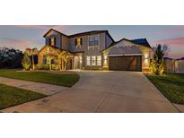 Stunning two-story home featuring a manicured lawn, stone accents and a spacious three-car garage at 32122 Wenlock Loop, Wesley Chapel, FL 33543