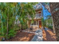 Charming two-story home featuring a cozy front patio with fire pit and lush tropical landscaping at 330 Lang N Ct # 1, St Petersburg, FL 33701