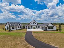 Breathtaking exterior view of the modern farmhouse, highlighting its expansive layout and pristine landscaping at 3515 Powerline Rd, Lithia, FL 33547