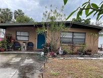 Charming single-story home featuring a quaint front porch, teal door, and a well-maintained lawn at 4104 W North B St, Tampa, FL 33609