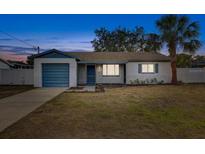 Charming single-story home with a well-maintained lawn and a quaint blue-accented garage at 416 Flamingo Dr, Apollo Beach, FL 33572