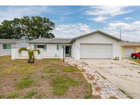 Charming single-story home featuring a two-car garage, manicured lawn, and inviting curb appeal at 564 5Th Se Ave, Largo, FL 33771