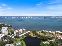 Panoramic aerial view of a waterfront condo with bay views and lush landscaping and pool in Sarasota, Florida at 100 Oakmont Ln # 305, Belleair, FL 33756