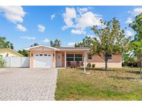 Charming single-story home featuring a brick driveway and a well-maintained front yard with mature landscaping at 10415 124Th Ter, Largo, FL 33773