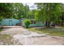 Single story home featuring a large yard with mature trees, showcasing its potential for outdoor enjoyment at 10854 Telford St, New Port Richey, FL 34654