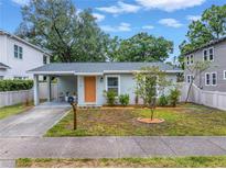Charming single-story home with well-kept lawn, covered parking, and a welcoming orange front door at 116 W Chelsea St, Tampa, FL 33603