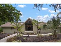 Inviting home featuring a modern A-frame design and professionally landscaped front yard with mature trees at 1204 Ballinger Rd, Lutz, FL 33548