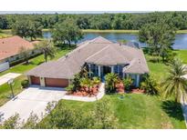 Waterfront home boasts lush landscaping, a two-car garage, and a meticulously maintained lawn at 12309 Creek Edge Dr, Riverview, FL 33579