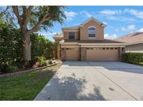 Charming two-story home featuring a three-car garage, landscaped yard, and welcoming curb appeal at 17809 Sandpine Trace Way, Tampa, FL 33647