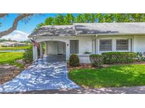 Charming villa featuring a covered carport and lush landscaping at 2014 Hampstead Cir, Sun City Center, FL 33573