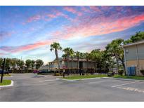 Exterior view of the apartment building with trees, sidewalk and reserved parking space at 213 Red Cedar Pl # 213, Brandon, FL 33510