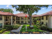 Charming condo building with lush landscaping, sidewalks, and a warm, inviting atmosphere, nestled amidst mature trees at 2412 Hammock Pine Blvd, Clearwater, FL 33761