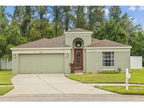 Charming single-story home with a two-car garage and well-manicured lawn at 26749 Middleground Loop, Wesley Chapel, FL 33544