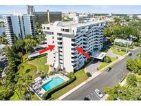 Aerial view of condominium complex with pool, covered parking, and balcony views at 30 Turner St # 704, Clearwater, FL 33756