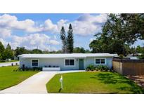 Charming single-story home featuring a well-manicured lawn, vibrant plants and a white mailbox and drive way at 3951 72Nd N St, St Petersburg, FL 33709