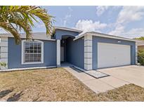 Charming home with a blue exterior, arched window, white trim and a two-car garage at 4555 Hannah Ln, St Petersburg, FL 33709