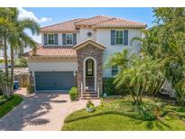 Charming two-story home featuring a tile roof, stone accents, and beautifully landscaped front yard at 4612 W Lowell Ave, Tampa, FL 33629