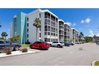Spacious condo building featuring multiple units, parking, and palm trees in a sunny, desirable location at 4908 38Th S Way # 206, St Petersburg, FL 33711