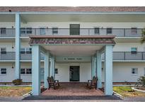 Inviting building entrance featuring a covered entryway with benches for residents and guests at 8 Glencoe Pl # 305, Dunedin, FL 34698