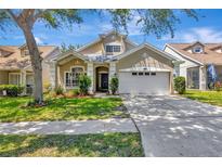 Charming home with a two-car garage, well-manicured lawn, and lovely landscaping at 10819 Newbridge Dr, Riverview, FL 33579