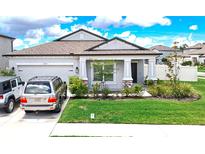 Charming single-story home featuring a well-manicured lawn and a two-car garage at 12687 Retreat Pl, Spring Hill, FL 34610