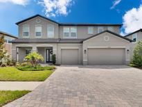 Beautiful two-story home with a well-manicured lawn and a spacious three-car driveway at 17845 Cortes Creek Blvd, Spring Hill, FL 34610