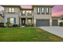 Stunning two-story home with three-car garage, manicured lawn, blue shutters and a balcony at 17914 Bramshot Pl, Lutz, FL 33559
