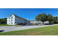 Exterior view of the multi-story condo building with well-maintained landscaping and ample parking at 2468 Florentine Way # 26, Clearwater, FL 33763