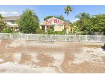 Charming colorful single-story home featuring unique exterior wall art, fenced yard and mature trees at 2624 54Th S St, Gulfport, FL 33707