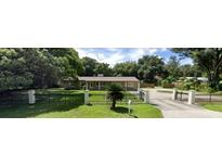 Charming single-story home with a well-manicured lawn and a black iron fence, offering a welcoming curb appeal at 312 N Hilltop Rd, Brandon, FL 33510
