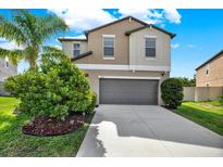 Charming two-story home featuring a two-car garage and beautifully landscaped front yard at 5067 Sable Chime Dr, Wimauma, FL 33598