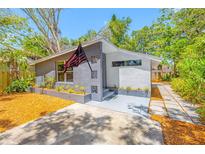 Charming single-story home featuring a gray and white exterior with an American flag at 612 Sw Beverly Ave, Largo, FL 33770