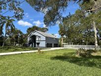 Charming two-story home with a well-manicured lawn and mature trees at 6521 Oelsner St, New Port Richey, FL 34652