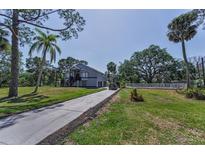 Two-story home features a long driveway and a well-manicured lawn with mature trees at 6521 Oelsner St, New Port Richey, FL 34652