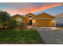 Charming one-story home features a two-car garage and beautifully landscaped front yard at 6914 Monarch Park Dr, Apollo Beach, FL 33572