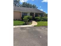 Charming villa with covered porch, mature landscaping, and well-maintained lawn at 9302 Trowbridge Ct, New Port Richey, FL 34655