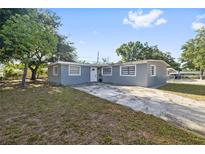 Charming single-story home featuring a well-manicured lawn and a long driveway leading to the residence at 2002 Waikiki Way, Tampa, FL 33619