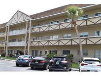 A low-rise multi-Gathering condominium building with a beautiful palm tree, and parking at 2463 Brazilia Dr # 43, Clearwater, FL 33763