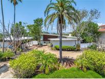 Charming mid-century home featuring lush tropical landscaping and well-maintained exterior at 31 Dolphin Dr, Treasure Island, FL 33706